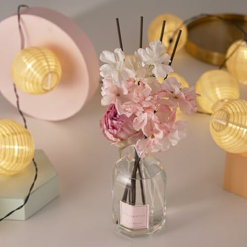 Blumen in einer Vase mit Lichtern im Hintergrund.