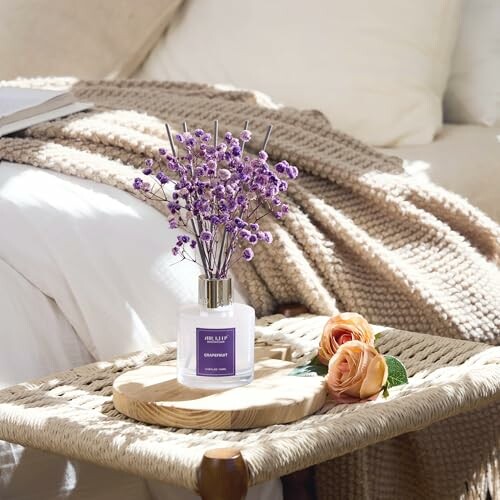 Lavendel in Vase auf Tisch neben Rosen